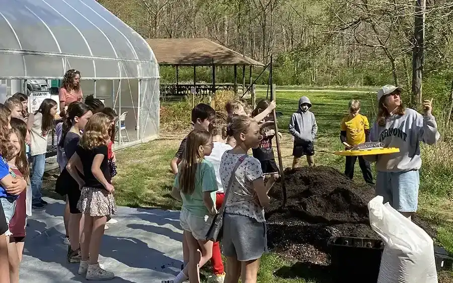 kids gathered around nursery with teacher